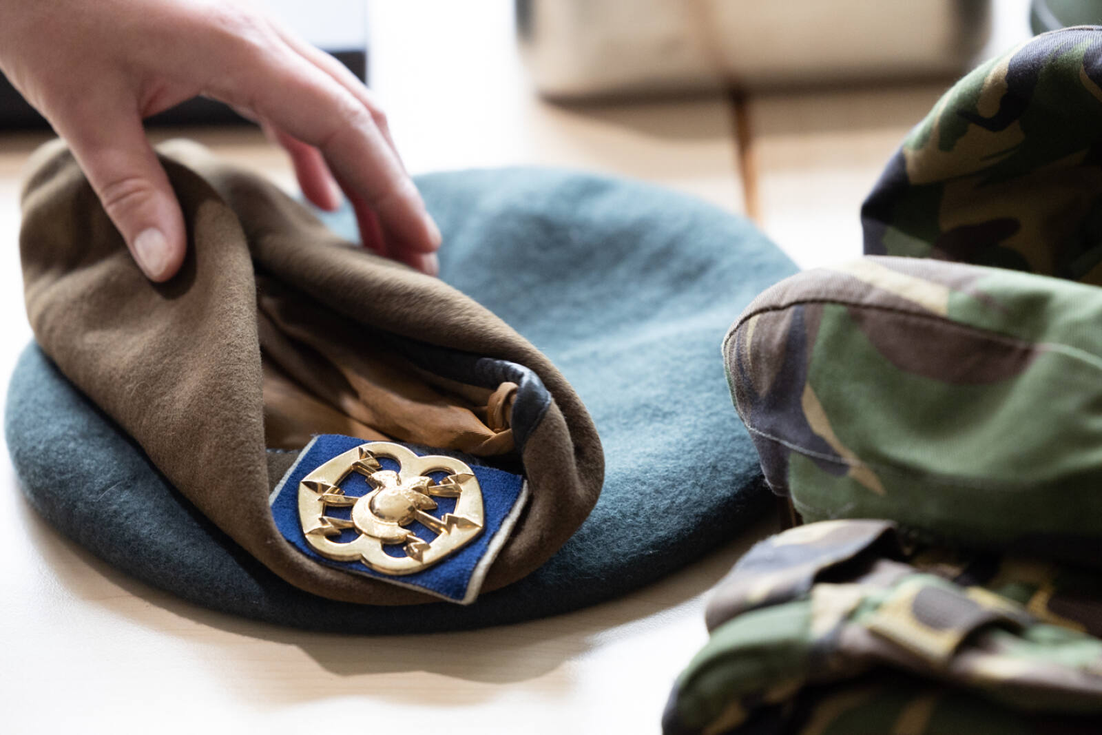 Verschillende kleuren baretten met embleemen.