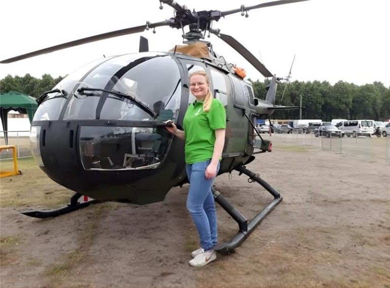 Vrijwilliger Denise staat voor een zwarte helikopter op het Malieveld, Den haag. Tijdens de Nederlandse Veteranendag.