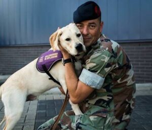 Op de foto staat links een KNGF geleidehond en rechts Niels Verheul.